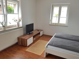Dormitorio con cama y tocador con TV en Ferienwohnung im Springerhof, en Lohr