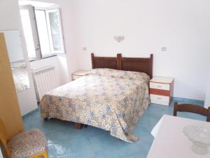 1 dormitorio con 1 cama, 2 mesas y una ventana en GRomano Apartments, en Isquia
