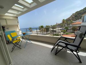 a balcony with chairs and a table and a view of the ocean at Casa vacanze La Balena2 in Capo dʼOrlando