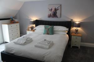 Un dormitorio con una cama blanca con toallas. en The White Lion en Ventnor