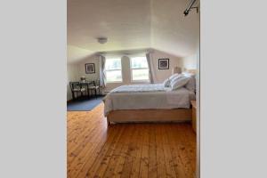 Grande-Digue的住宿－Beautiful 2 Bedroom Apartment in Shediac Bridge，一间卧室配有一张床,铺有木地板