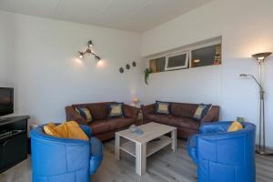 ein Wohnzimmer mit 2 Sofas und einem Tisch in der Unterkunft Strandslag appartement 223 - Julianadorp aan zee in Julianadorp