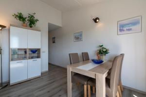 ein Esszimmer mit einem Holztisch und Stühlen in der Unterkunft Strandslag appartement 223 - Julianadorp aan zee in Julianadorp