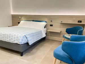 um quarto com uma cama e uma cadeira azul em Hotel Locanda Alla Perla em Ledro