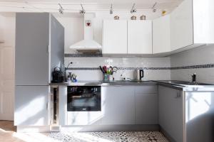 eine weiße Küche mit weißen Schränken und einem Backofen in der Unterkunft À 150m de la Grande Plage des Sables d'Olonne in Les Sables-dʼOlonne + 18 Fotos