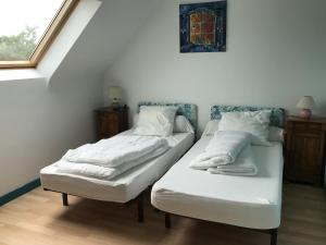 two twin beds in a room with a window at Maison avec jardin pour 10 - 600m plage in Arzon