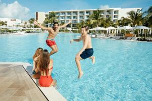 a man jumping up into the air to catch a frisbee at Grand Palladium Costa Mujeres Resort & Spa - All Inclusive in Cancún