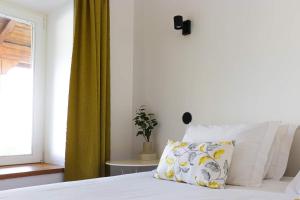 1 dormitorio con cama con almohada y ventana en Villa dos Corcéis, en Esposende