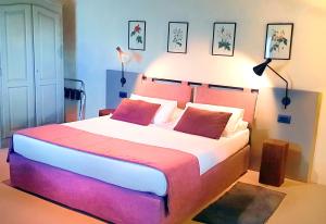 a bedroom with a large bed with two red pillows at Il Palagione in San Gimignano