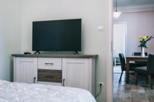 telewizor z płaskim ekranem na komodzie w sypialni w obiekcie Bringa Villa w mieście Balatonlelle