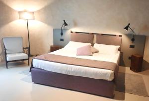 sypialnia z dużym łóżkiem i krzesłem w obiekcie Il Palagione w mieście San Gimignano