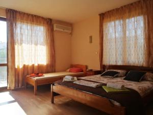 a bedroom with two beds and a large window at Guest House "Zora - Sarafovo" in Burgas