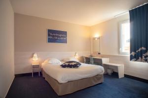 um quarto de hotel com uma cama e uma secretária em ACE Hôtel Lyon Vénissieux Parc des Expositions em Vénissieux
