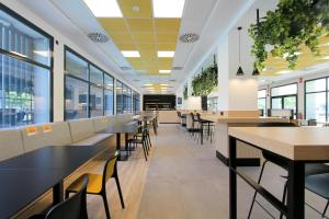 a cafeteria with tables and chairs and windows at Villa Alojamiento y Congresos - Villa Universitaria in San Vicente del Raspeig