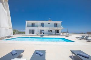 a villa with a swimming pool in front of a house at Villa Marylou in Protaras