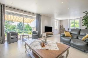 een woonkamer met een bank en een tafel bij Les Ormes - Grande maison avec Jacuzzi in Largny-sur-Automne