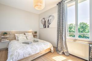 Schlafzimmer mit einem Bett und einem Fenster in der Unterkunft Les Ormes - Grande maison avec Jacuzzi in Largny-sur-Automne