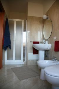 uma casa de banho com um lavatório, um WC e um espelho. em Sun and Beach em Catona