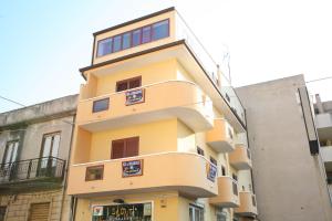 a yellow building with blue signs on it at Sun and Beach in Catona