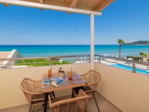 a balcony with a table and chairs and the ocean at Paradise Studios & Apartments in Alykes