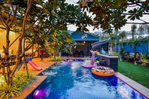 una piscina en un patio trasero con parque infantil en Emmy pool villa-1(Cha-am), en Cha Am