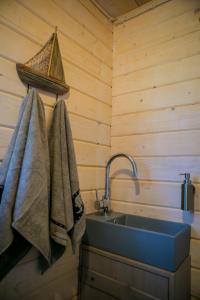 Un baño con lavabo y toallas en la pared. en Valipe Puhkemaja, en Valipe