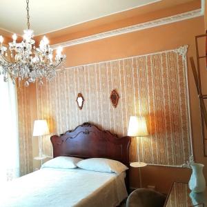 a bedroom with a bed and a chandelier at Adeste 33 in Scicli