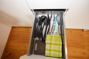 eine mit Küchenutensilien gefüllte Schublade in einer Küche in der Unterkunft Alpenblick - Modernes Apartment in Ruhelage in Villach