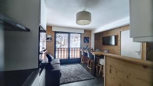 a kitchen with a counter and a table with chairs at MAGNIFIQUE APPARTEMENT REFAIT à NEUF - CALME - 2 Chambres - 6 Personnes - Vue Montagne GRAND CERF 65 in Saint-Jean-d'Aulps