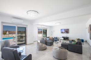 a living room with couches and chairs and a pool at Villa Marylou in Protaras