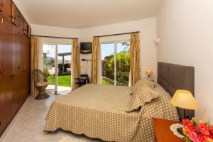 een slaapkamer met een bed en een groot raam bij Monte Lemos 29 in Luz +36 foto's