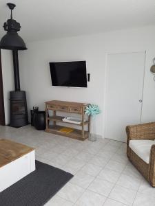 ein Wohnzimmer mit einem Flachbildfernseher an der Wand in der Unterkunft 500m de la plage des Boucholeurs - Maison pour 5 in Barbâtre