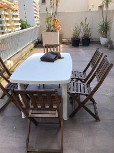 d'une table blanche et de deux chaises sur un balcon. dans l'établissement Ajaccio centre ville cosy et spacieux avec climatisation, grande terrasse et vue mer, à Ajaccio