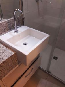 - Baño con lavabo blanco y ducha en Apto à beira-mar com wi-fi e piscina em Fortaleza, en Fortaleza