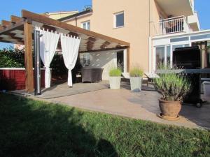 patio z białymi parasolami i drewnianą pergolą w obiekcie Apartment in Zambratija with sea view, balcony, air conditioning, WiFi (4961-3) w mieście Zambratija
