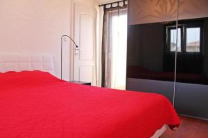 czerwone łóżko w pokoju z oknem w obiekcie Apartment in Zambratija with sea view, balcony, air conditioning, WiFi (4961-3) w mieście Zambratija