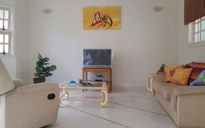 a living room with two couches and a coffee table at Casa com churrasqueira no Centro de Caraguatatuba in Caraguatatuba