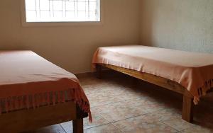 2 Betten in einem Zimmer mit Fenster in der Unterkunft Casa com churrasqueira no Centro de Caraguatatuba in Caraguatatuba