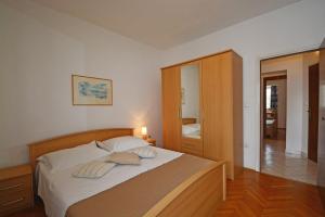 Un dormitorio con una cama con dos almohadas encima. en Apartment in Duce with sea view, terrace, air conditioning, WiFi 4969-1, en Duće