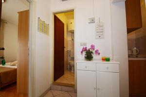 Una cocina con un armario blanco con flores. en Apartment in Duce with sea view, terrace, air conditioning, WiFi 4969-1, en Duće 37 fotos más