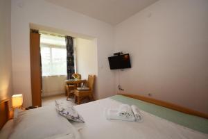Un dormitorio con una cama y un televisor en la pared. en Apartment in Duce with sea view, terrace, air conditioning, WiFi 4969-1, en Duće