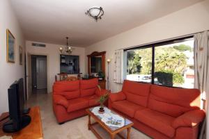 salon z 2 czerwonymi kanapami i telewizorem w obiekcie Apartment Burriana Spainsunrentals 1162 w mieście Nerja