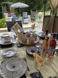 - une table avec des assiettes et des bouteilles de vin dans l'établissement Le Petit Pont, à Magnac-Laval