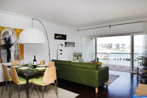 a living room with a green couch and a table at Remarkable view over Cascais Bay in Cascais
