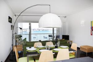 a dining room and living room with a table and chairs at Remarkable view over Cascais Bay in Cascais
