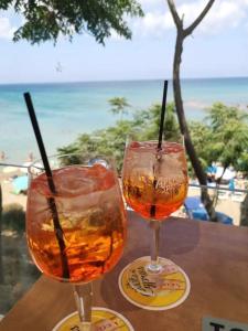 two glasses on a table with a view of the beach at Protaras Ionian Breeze House in Paralimni