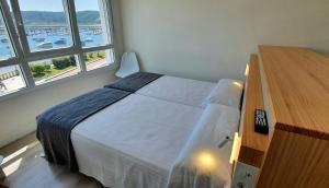 A bed or beds in a room at Apartamentos Costa da Morte Muxia