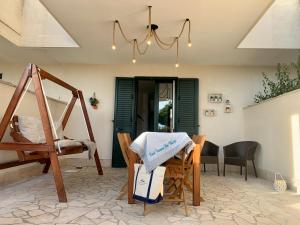 jadalnia ze stołem, krzesłami i żyrandolem w obiekcie Panoramic by Casa Vacanze Dei Bacini w mieście Porto Cesareo