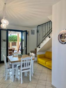 jadalnia ze stołem, krzesłami i kanapą w obiekcie Panoramic by Casa Vacanze Dei Bacini w mieście Porto Cesareo