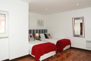 a white room with two beds and a mirror at Fashionable and Modern Apartment - Cascais in Cascais